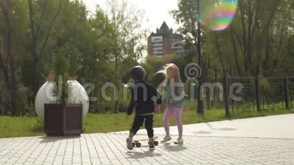 一个戴着头盔的学龄前男孩在公园里骑车夏天视频的预览图