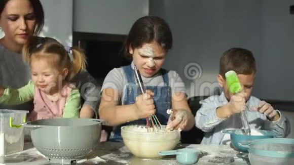 一位带着三个孩子的年轻母亲为饺子和馄饨准备面团斯拉夫菜俄罗斯菜慢动作视频的预览图