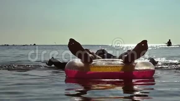 戴太阳镜的年轻游客在海上充气床垫上放松动作缓慢1920x1080视频的预览图