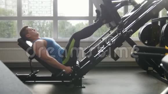 健身俱乐部肌肉男在腿部按压机上锻炼视频的预览图