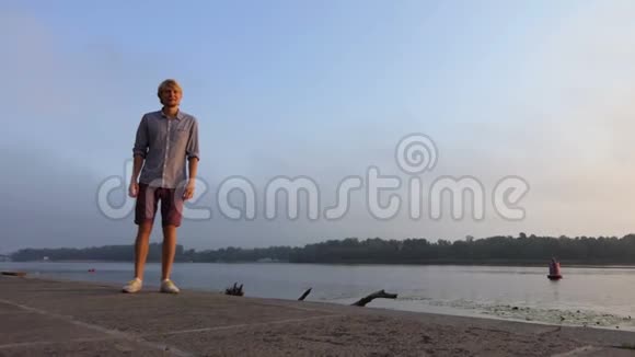 斯洛莫日落时分穿短裤的年轻人沿着第聂伯罗河岸快速奔跑视频的预览图