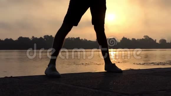在斯隆莫的夕阳下雄腿在令人印象深刻的河岸上跳舞视频的预览图
