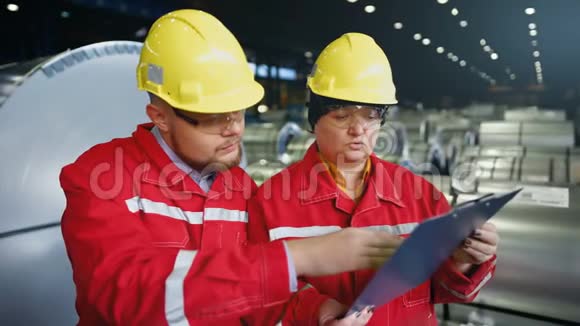两名工人在生产工厂作为团队讨论工业现场背景视频的预览图