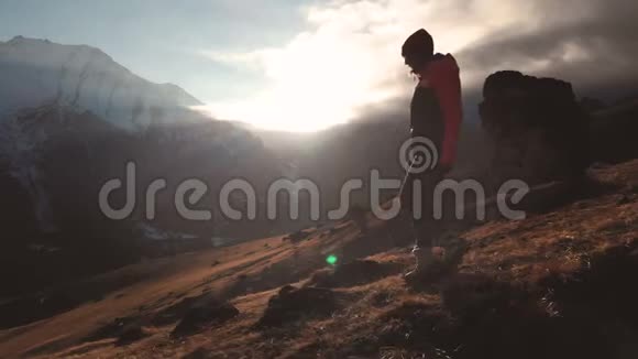 在美丽的日落中一个女孩走在山的边缘作为一个剪影的史诗般的空中景色视频的预览图