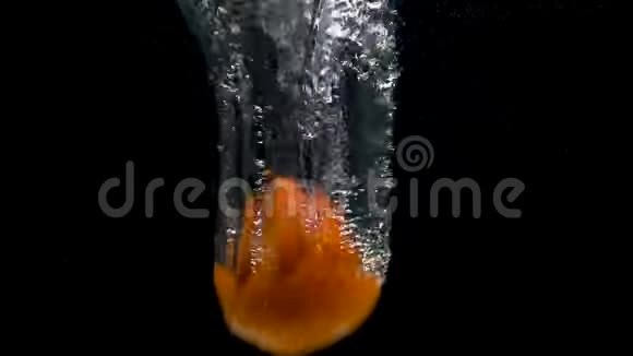 黑色背景下水中落下的柿子的足迹视频的预览图