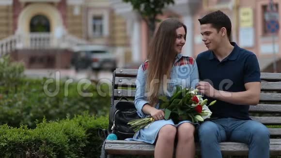 可爱的情侣坐在公园的长椅上视频的预览图