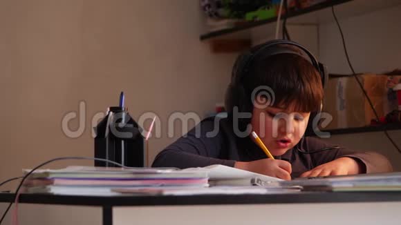一个戴着大耳机的男孩正在写作业视频的预览图