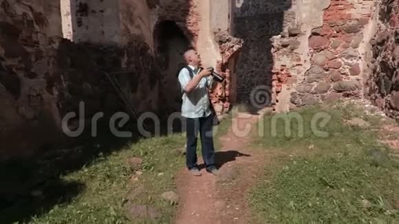 在古堡废墟上拿着相机的人视频的预览图