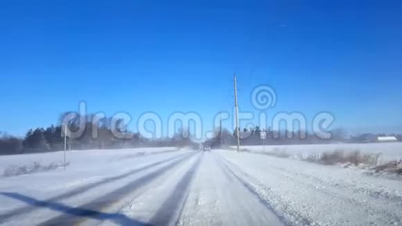 在白天驾驶冬季农村公路乡村街白天下雪视频的预览图