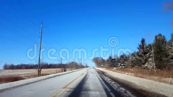 在白天驾驶冬季农村公路乡村街白天下雪视频的预览图