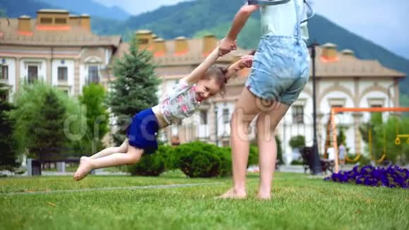 两个快乐的小姐姐女孩在夏天的绿草上玩得很开心视频的预览图