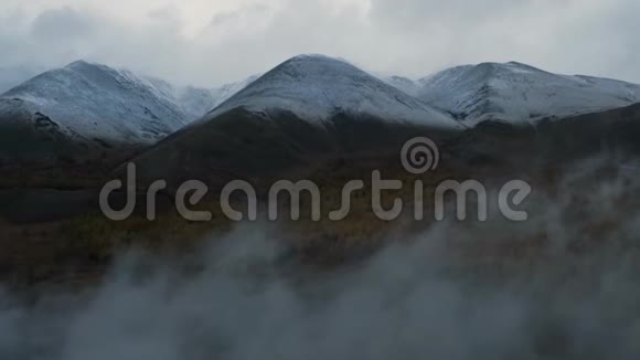 空中无人机通过低云向森林山谷和雪山射击视频的预览图