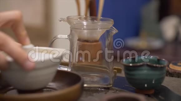 男用手将冲泡好的绿茶倒入玻璃茶壶中视频的预览图