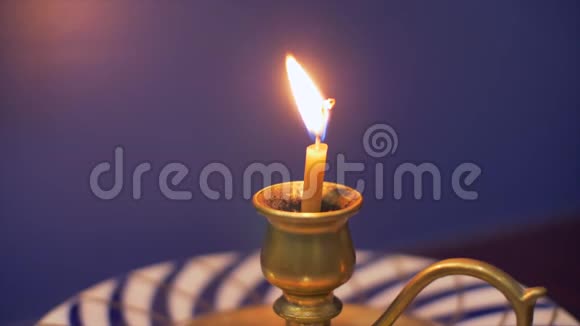 烛台上的蜡烛烛台上蓝色背景的桌子上放着碟子视频的预览图