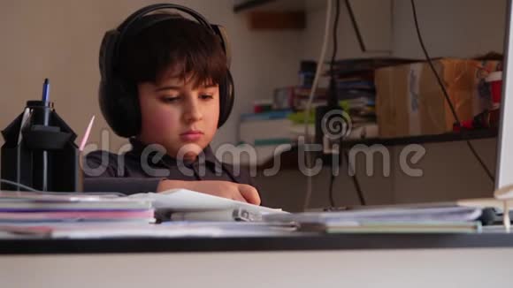 一个戴着大耳机的男孩正忙着看书视频的预览图