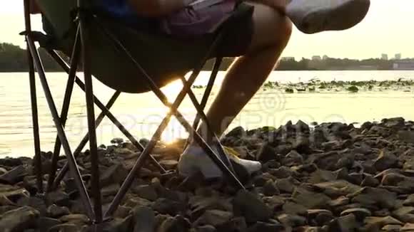 有创意的人坐在河岸上做梦把东西写在记事本上视频的预览图