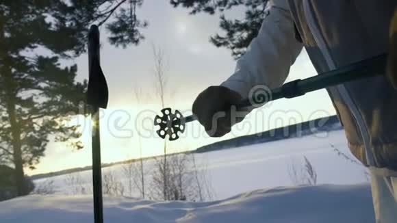 徒步旅行者在雪山上使用手杖日落时使用中段视频的预览图