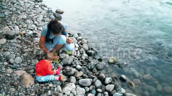 妈妈和宝宝坐在河岸上视频的预览图