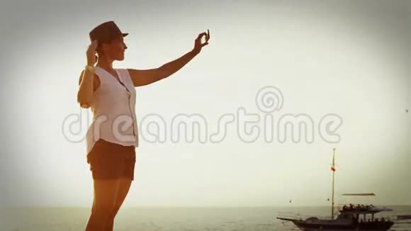 老电影特效镜头一个女人站在海边拍自己的照片视频的预览图