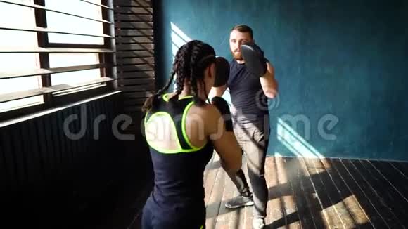 与拳击教练一起在健身房进行的适合白人女性拳击手训练视频的预览图