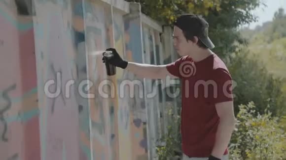 小男孩偷偷地在街墙上涂鸦视频的预览图