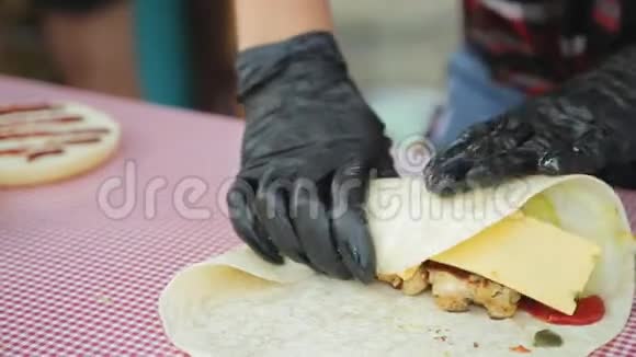 用手套煮把奶酪肉蔬菜和酱包在皮塔面包里视频的预览图
