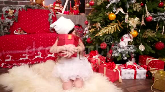 幸福快乐的小女孩收到了圣诞老人送给她的礼物新年有圣诞树的房间视频的预览图