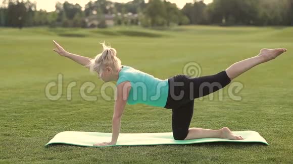 吸引人的成年女性在公园里练习瑜伽视频的预览图