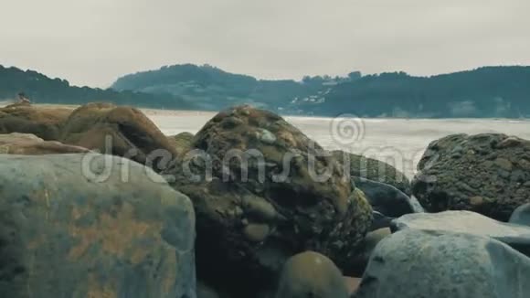 4k大西洋沿岸阴天有不同颜色的岩石橙色的沙子和海浪坎塔布里亚海滨视频的预览图