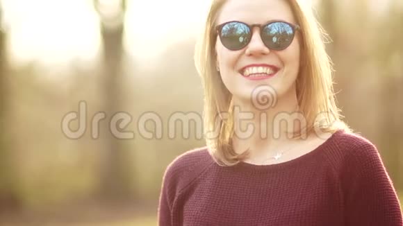 一个可爱的中年妇女严肃而不动声色地看着镜头她戴着太阳镜一个女孩休息视频的预览图