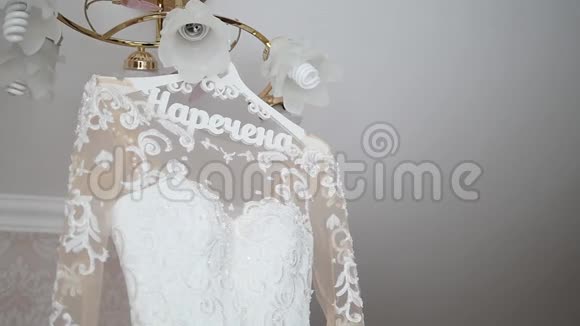 新娘的礼服挂在灯上婚纱挂在新娘的房间里白色婚纱挂在上面视频的预览图