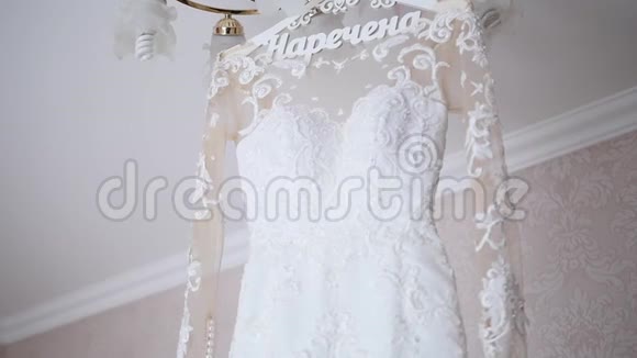 新娘的礼服挂在灯上婚纱挂在新娘的房间里白色婚纱挂在上面视频的预览图