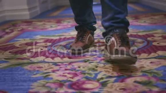 在走廊客人酒店的地毯地板上行走的男脚运动鞋视频的预览图