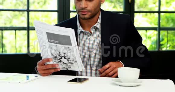 商人一边看报纸一边喝咖啡视频的预览图
