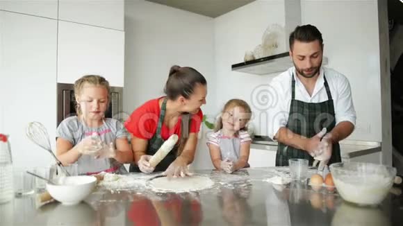 快乐的家庭烹饪在一起年轻的女儿正在帮助他们的父母他们有很多乐趣视频的预览图