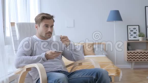 在休闲椅上坐着的成年人一边喝咖啡一边放松视频的预览图