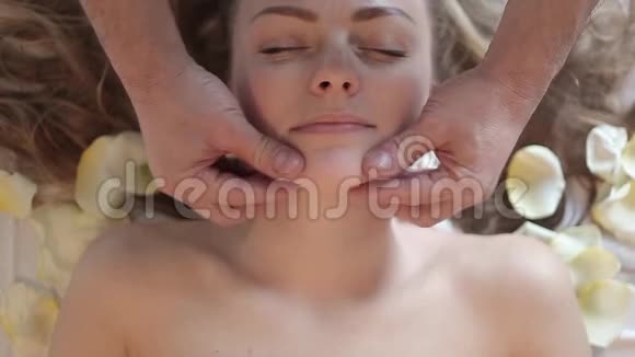 面部按摩在温泉沙龙按摩的女人身体护理视频的预览图