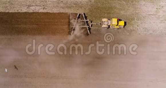 拖拉机在田野上的航迹鹳在犁后飞翔视频的预览图
