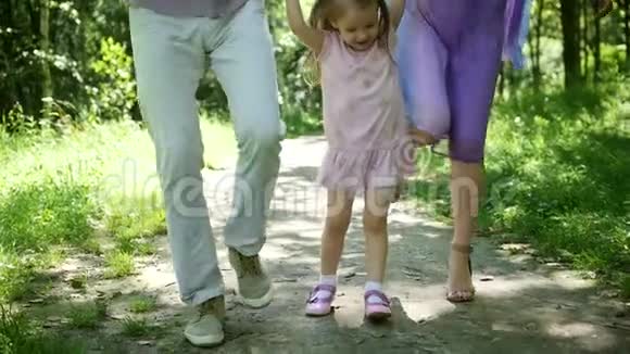 公园里的家庭金发小女孩父亲和母亲有有趣的户外慢动作视频的预览图