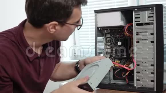 一名集中的计算机服务人员在眼镜中的特写镜头在办公室修理一台坏电脑并升级视频的预览图