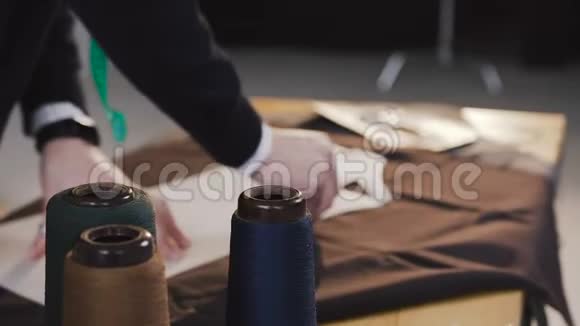 时装设计师或裁缝工作与织物在工作室充满裁剪工具图案剪刀卷尺视频的预览图