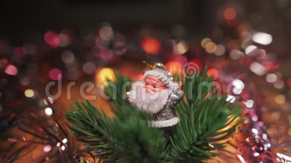 一个小小的银色圣诞老人的身影站在一个红色的圣诞节旁边在人造圣诞树上挂着包布圣诞节视频的预览图