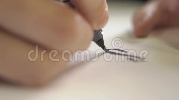 手是用毛笔在纸上印好的字母书写的视频的预览图