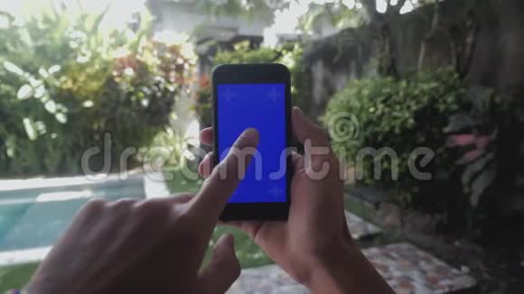 院子里户外智能手机男性手触摸特写蓝屏Chroma键视频的预览图