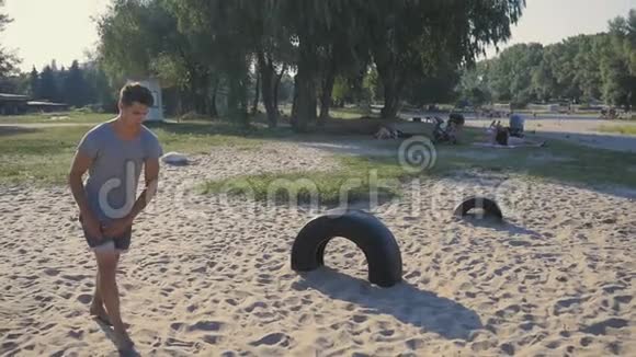 年轻人自由落体在海滩上做后翻动作跑酷运动员做杂技元素视频的预览图