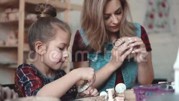 一个小女孩正在制陶车间里做一件泥工妈妈和孩子一起做创造性的工作视频的预览图