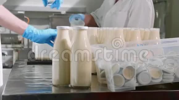 牛奶厂的工人用手把牛奶装在瓶子里视频的预览图