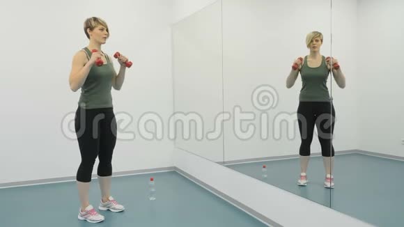 女人在健身房锻炼肱二头肌视频的预览图