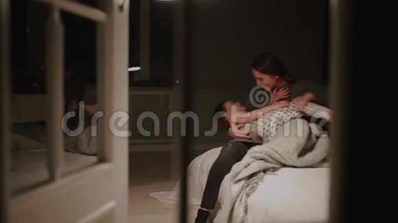 妈妈和儿子在卧室的床上玩男孩穿着睡衣不想睡觉视频的预览图