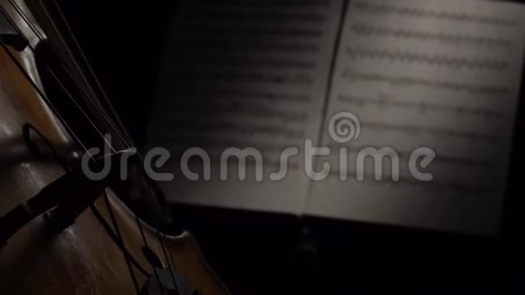 大提琴在黑暗中弓着弦在音符后面快关门侧视图视频的预览图